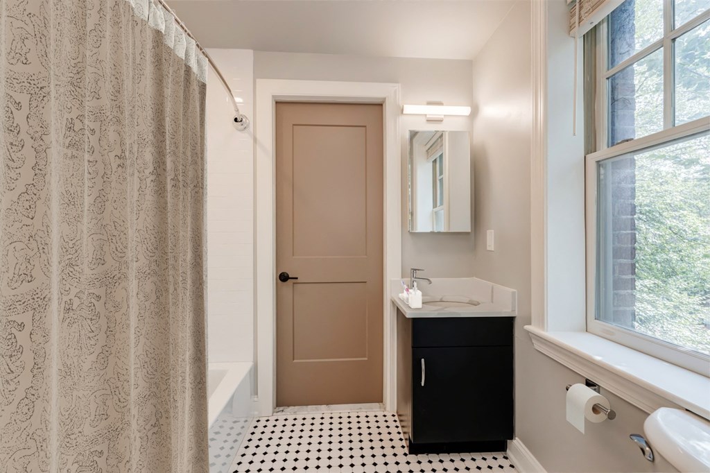a bathroom with a shower and a sink and a door