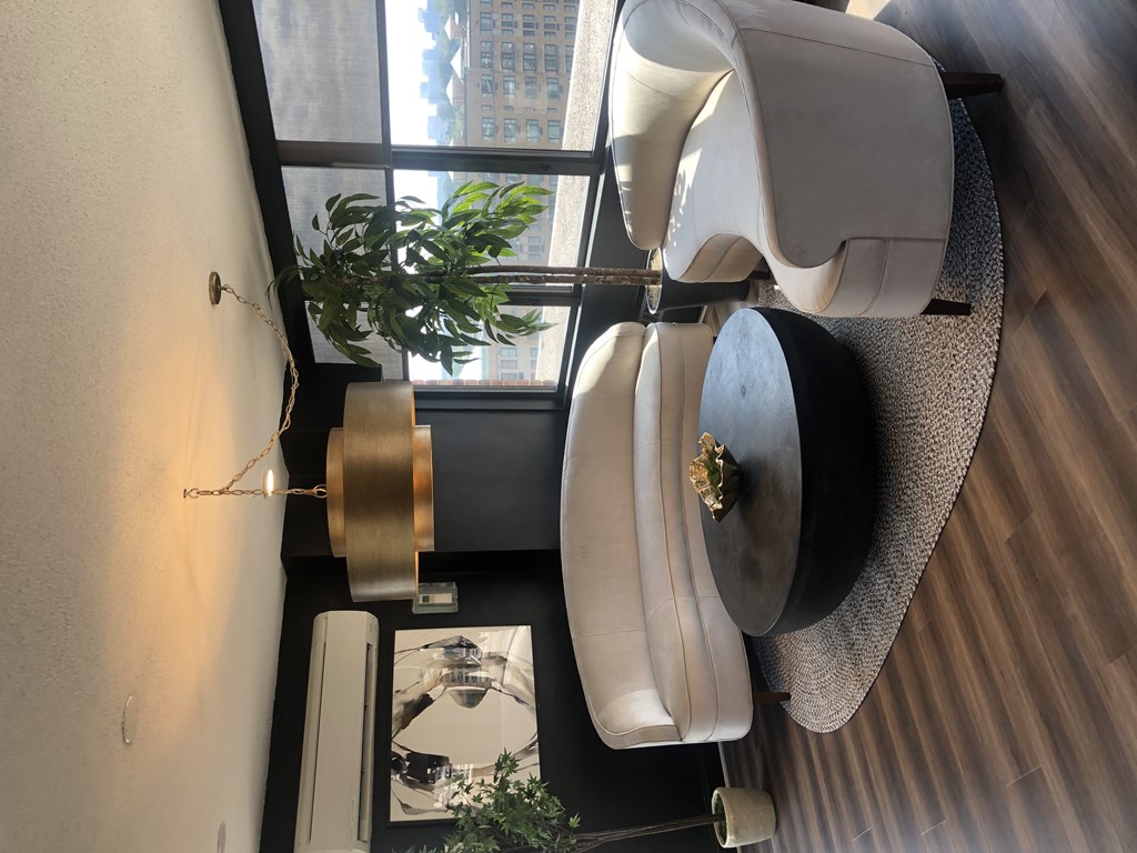 A black hat with a gold emblem sits on a white chair.