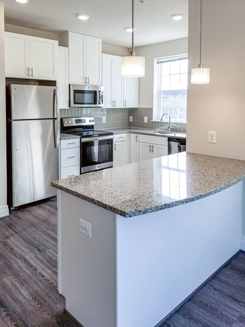 a kitchen with white cabinets and a granite counter top