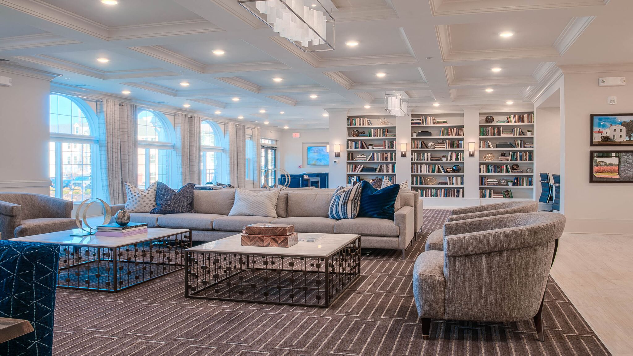a living room with couches and chairs and bookshelves