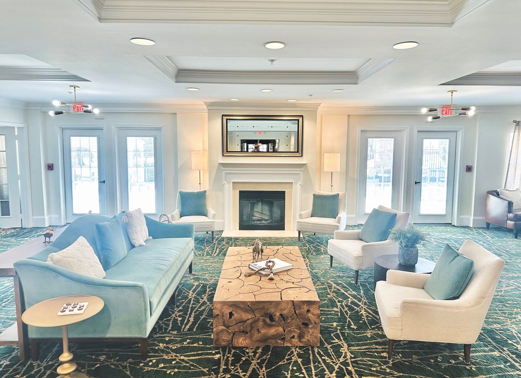 a living room with blue couches and chairs and a fireplace at Evergreens at Smith Run, Virginia, 22401
