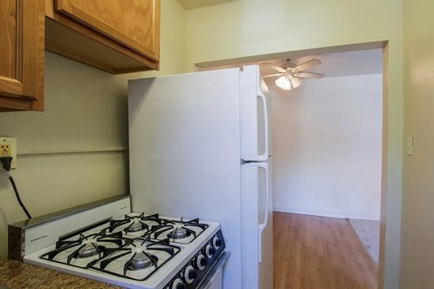 A white refrigerator is in a kitchen with a stove below it.