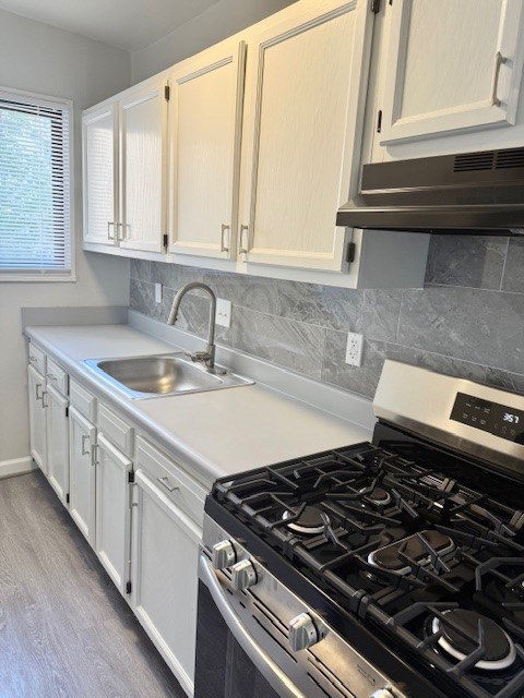 A kitchen with a black stove top oven and white cabinets.