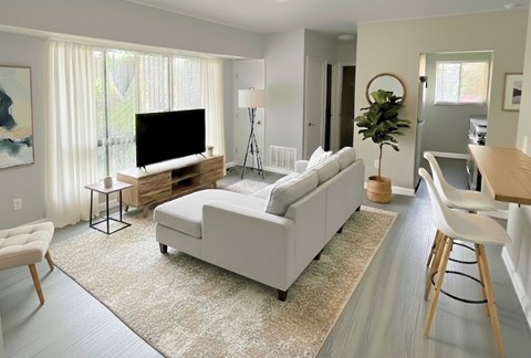 A living room with a white couch and a television.