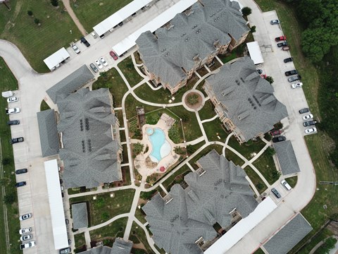 A bird's eye view of a residential area with houses and a swimming pool.