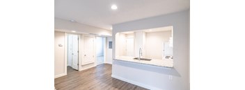 A modern kitchen with a sink and a large mirror.