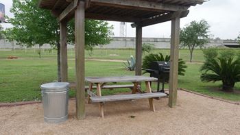 A picnic table is under a wooden shelter.