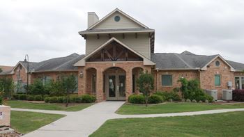 A house with a brown roof and a white wall with a small window.