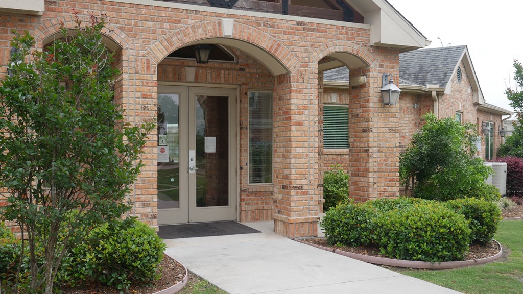 A brick building with a glass door and window.