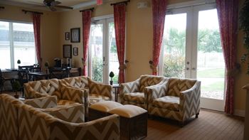 A living room with a sofa, armchairs, and a table.