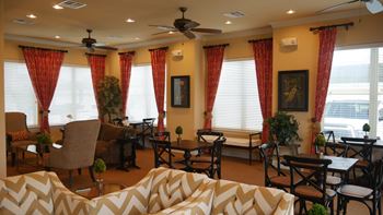 A living room with a white sofa and a ceiling fan.