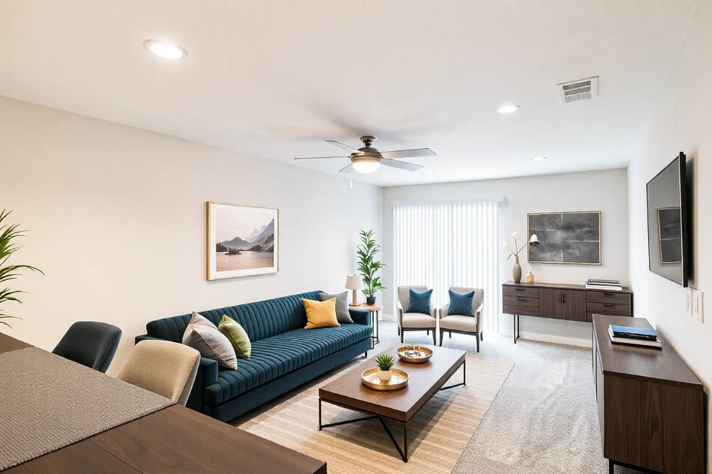 A living room with a blue couch and a wooden coffee table.