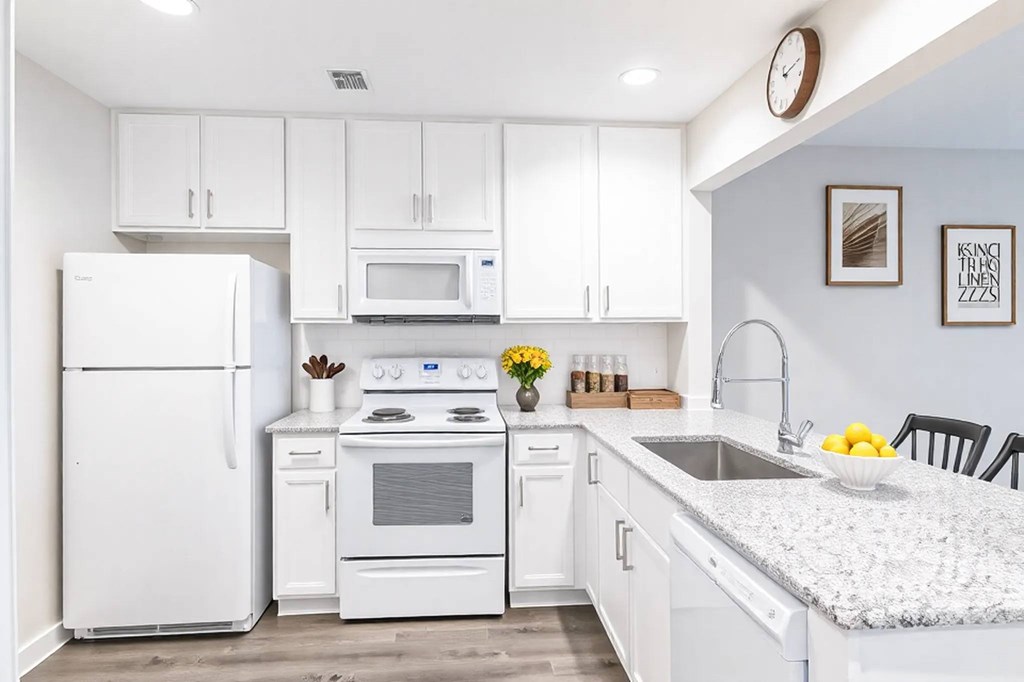 A kitchen with white appliances and cabinets.