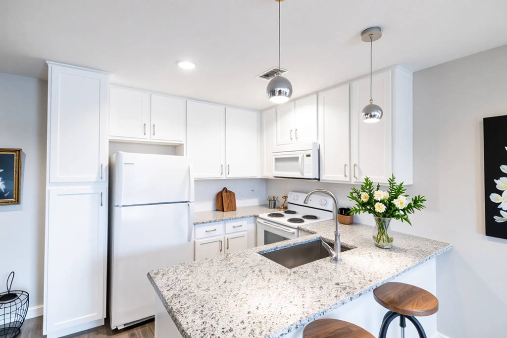 A kitchen with a white refrigerator and a marble countertop.