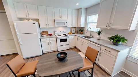A kitchen with white cabinets and a white refrigerator.