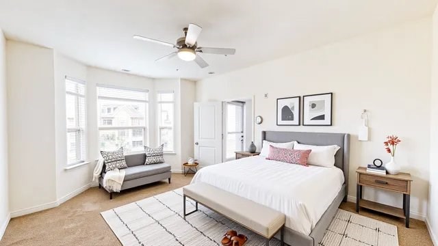 A bedroom with a large bed, a couch, and a ceiling fan.