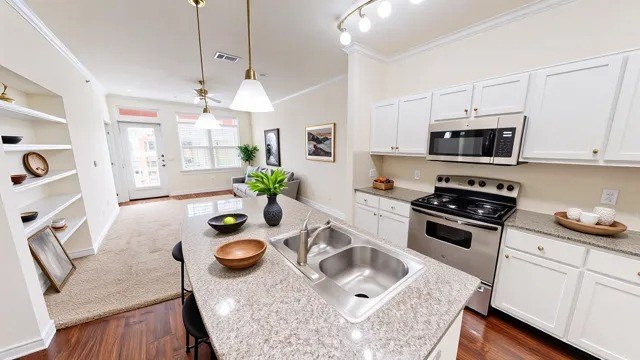A kitchen with white cabinets and a granite countertop.