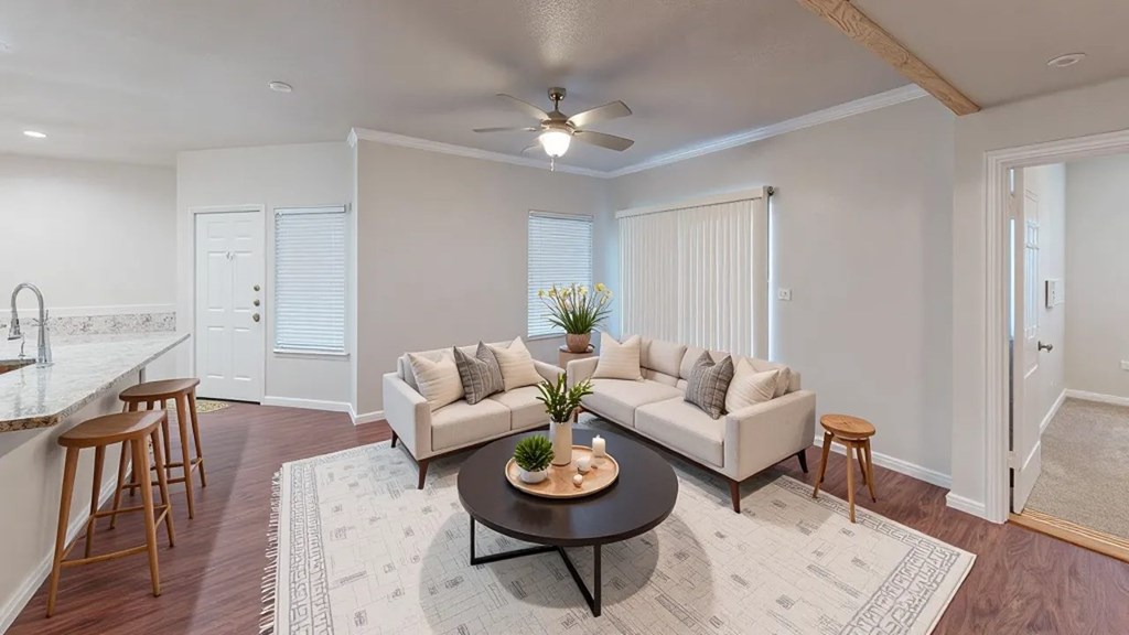 A living room with a white couch, a coffee table, and a ceiling fan.