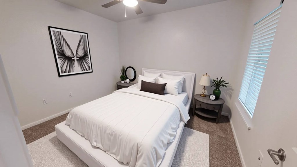 A bedroom with a white bed and a picture of a butterfly on the wall.