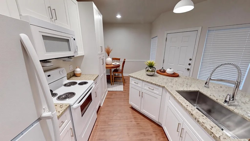 A kitchen with white appliances and cabinets.