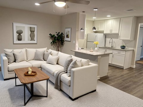 A modern living room with a white sofa and a wooden coffee table.