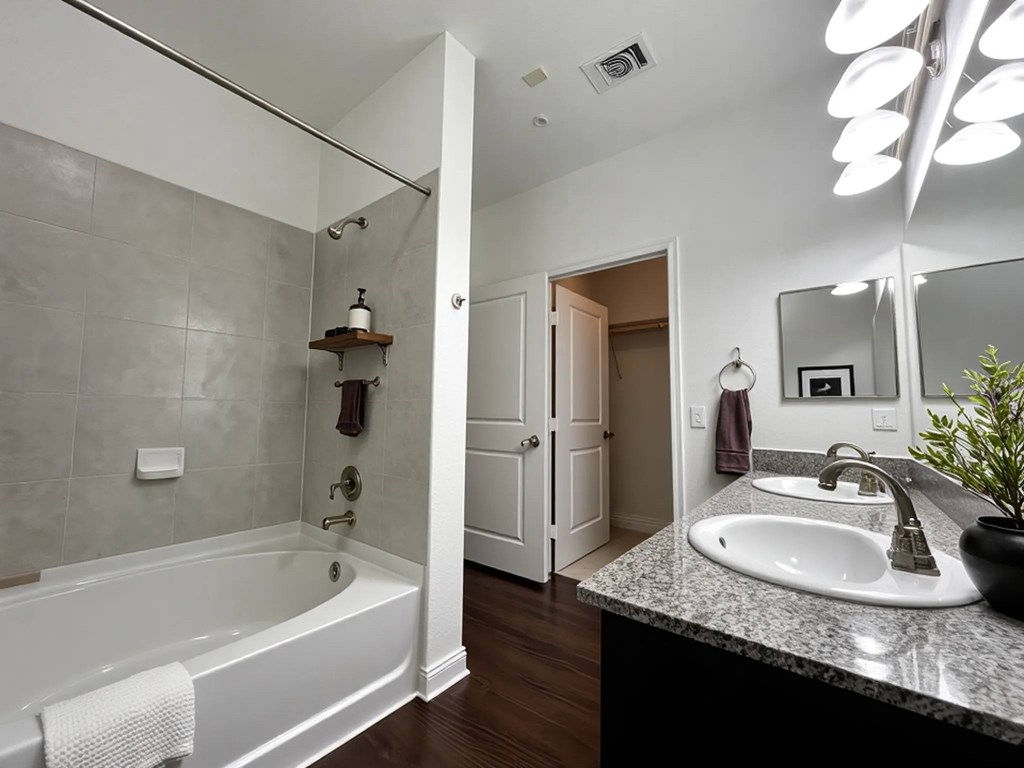 A bathroom with a white tub and sink.
