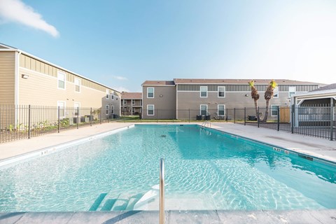 A pool in front of apartment buildings.