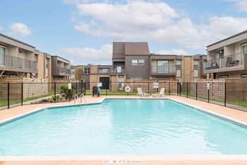 A swimming pool in front of apartment buildings with a sign that says "NO DIVING".