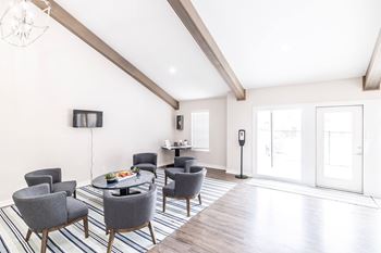 A living room with grey chairs and a wooden floor.