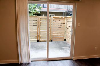 A room with a sliding door leading to a concrete patio.