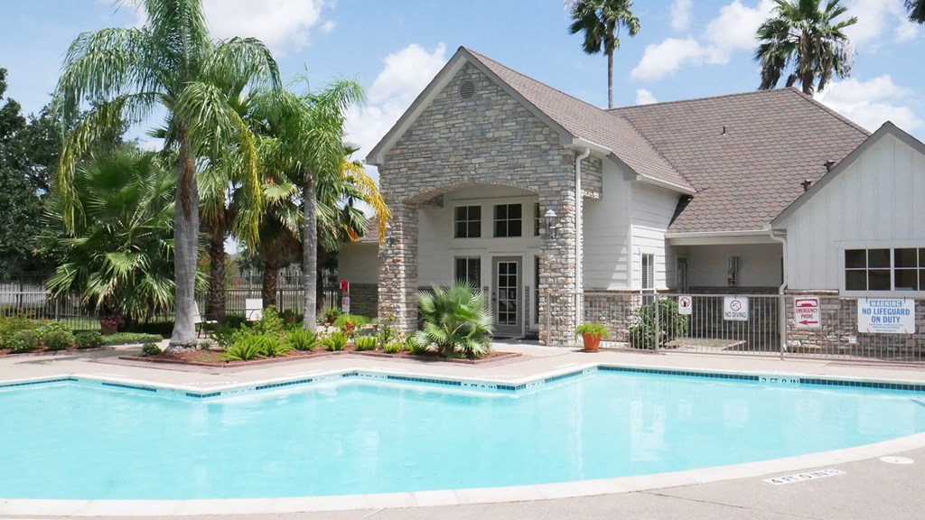 A house with a pool in front of it.