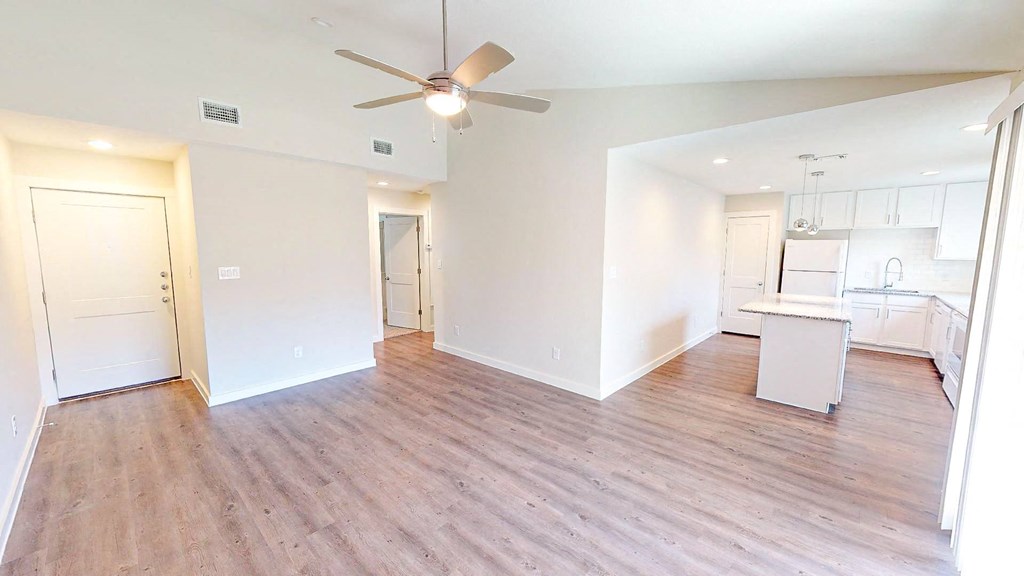 A room with a ceiling fan and wooden flooring.