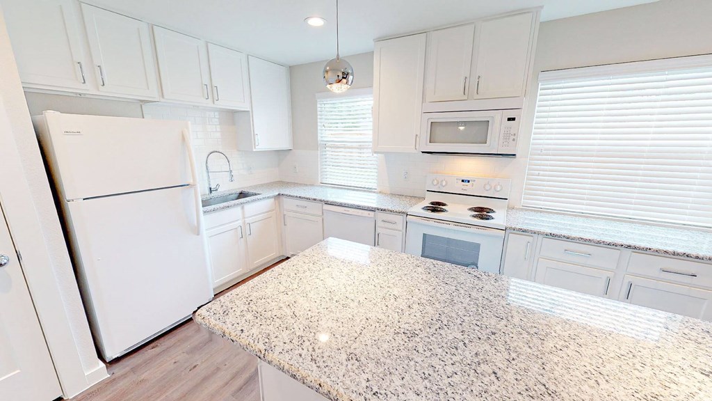 A kitchen with white cabinets and appliances.