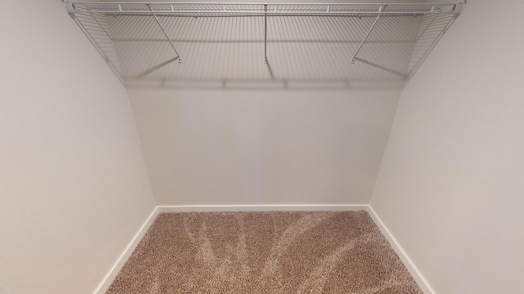 A room with a carpeted floor and a ceiling fan.