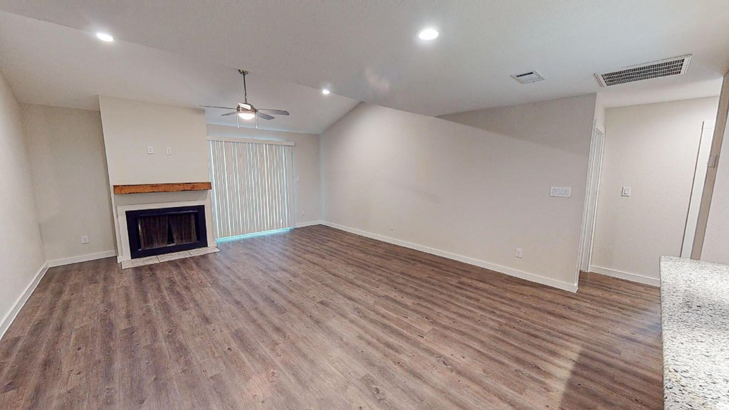 A room with a fireplace and wooden flooring.