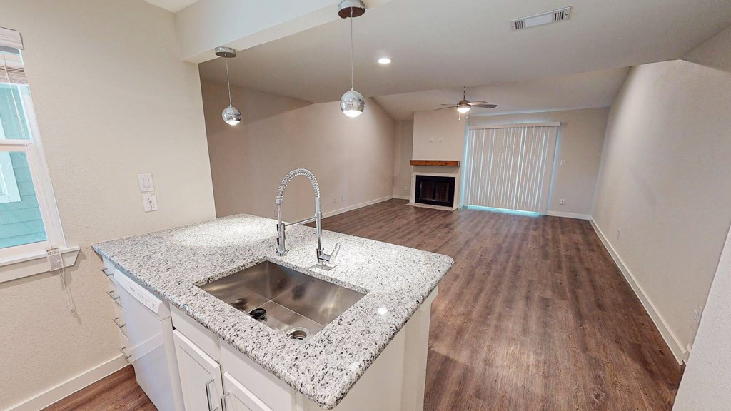 A kitchen with a granite countertop and a sink.