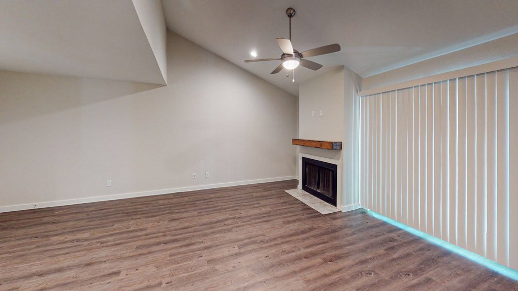 A room with a fireplace and a ceiling fan.