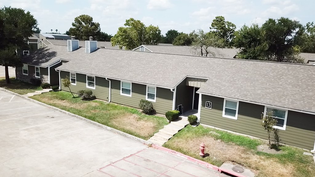 A parking lot in front of a building with a fire hydrant.