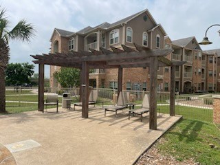 A large building with a wooden pergola in front of it.