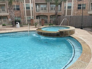 A small pool with a hot tub in the middle of it.