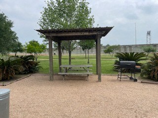 A picnic area with a grill and a table.