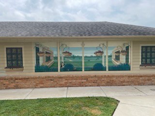 A house with a mural of a bear and a bird on the side.