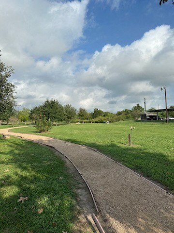 A pathway in a park with grass on either side.