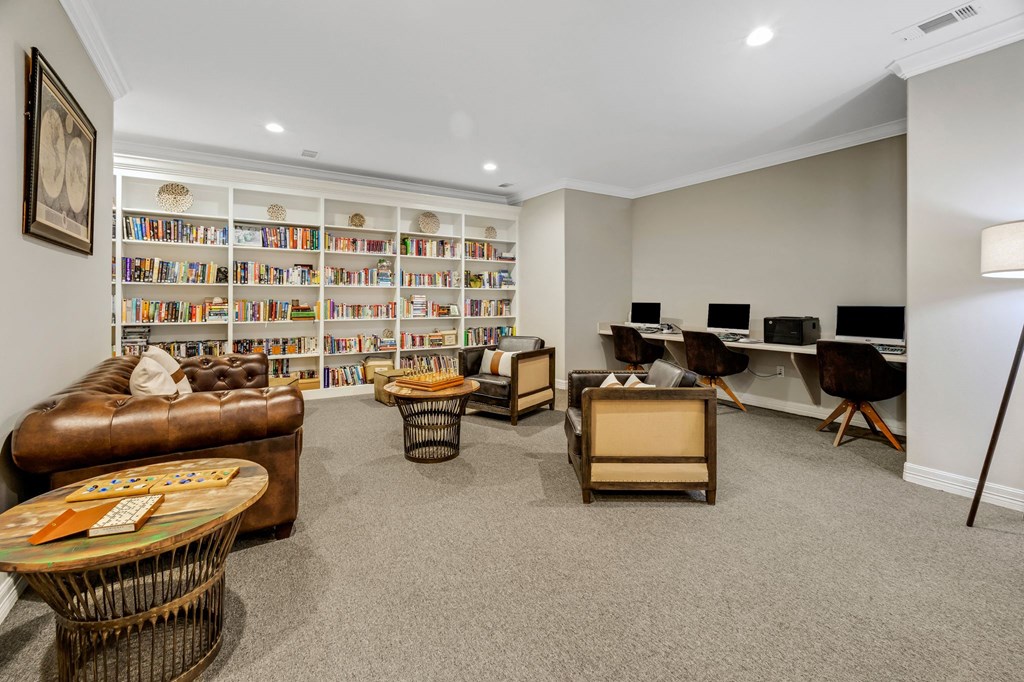 the living room has a library and a desk with computers