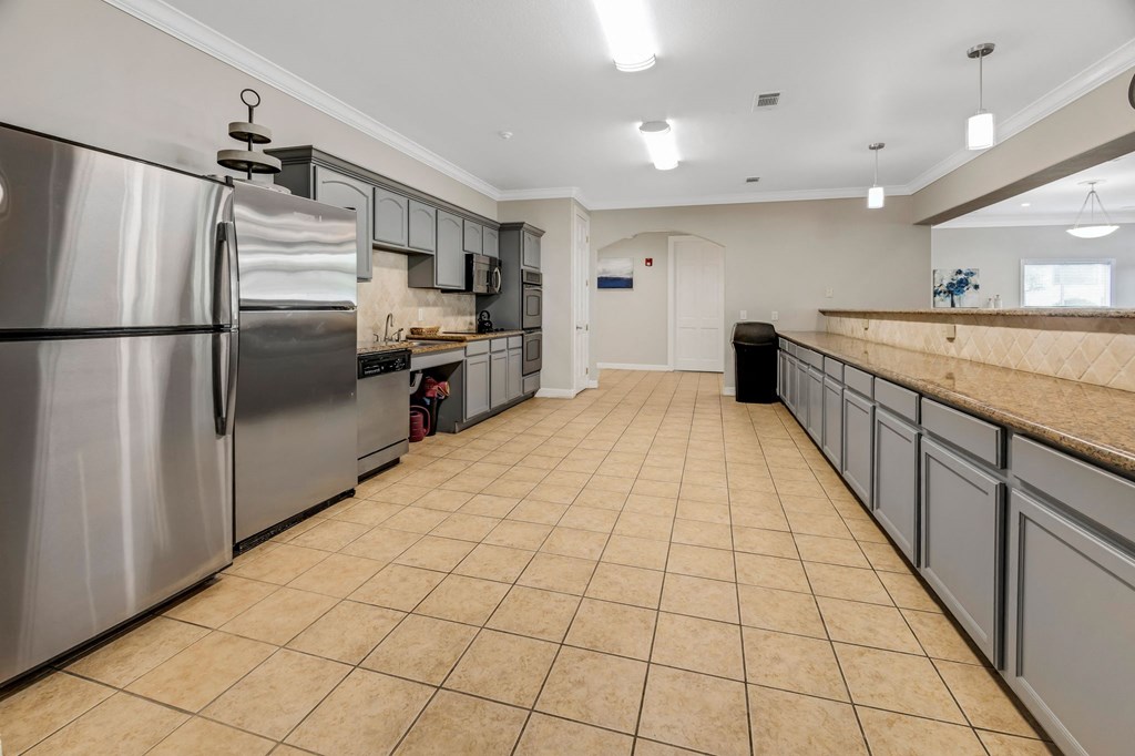 a large kitchen with stainless steel appliances and tile flooring