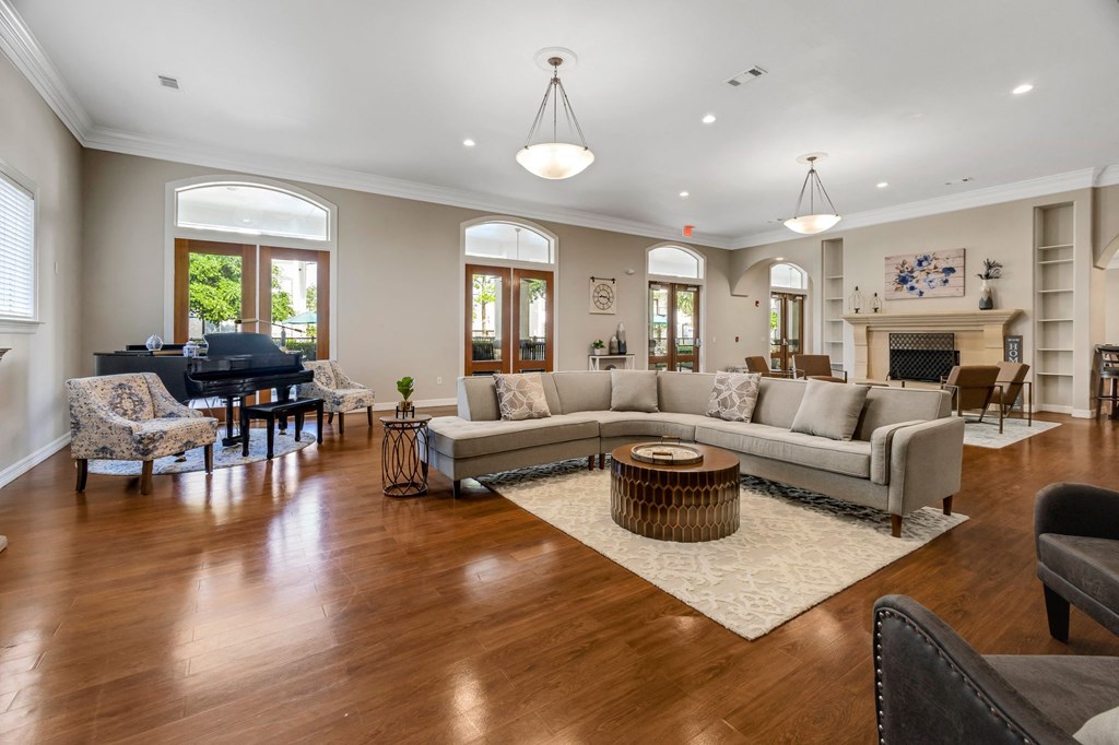 a living room with couches and chairs and a piano