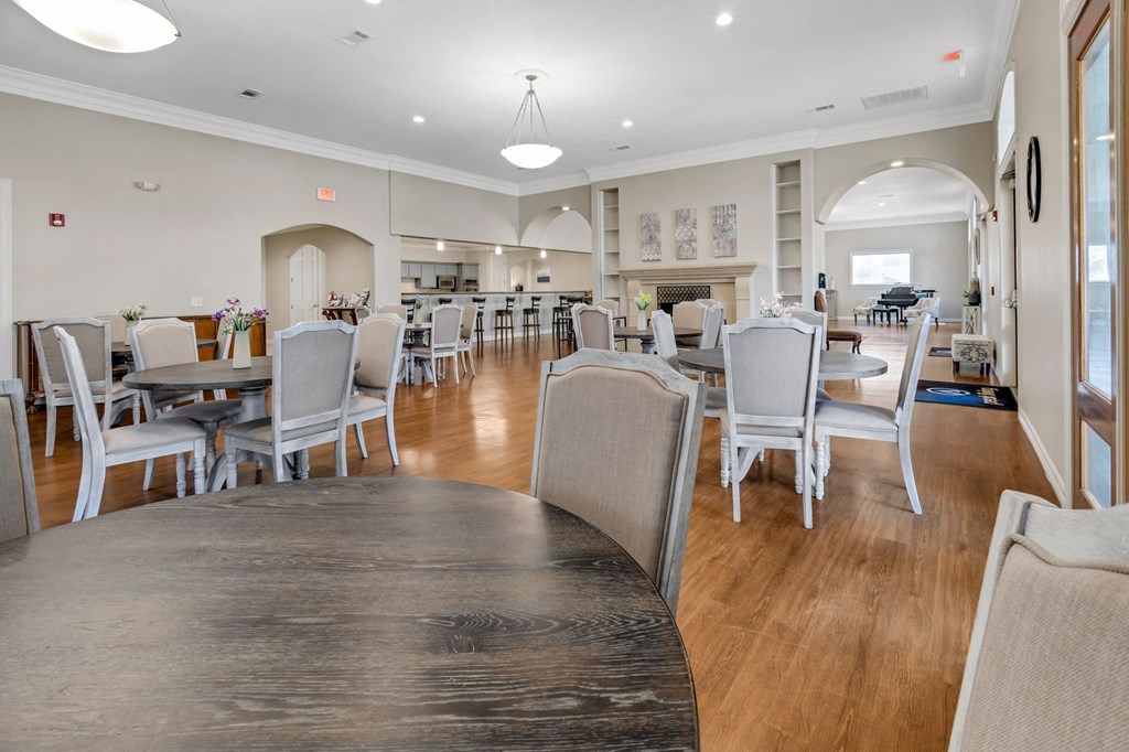 a dining room with tables and chairs and a living room with a fireplace