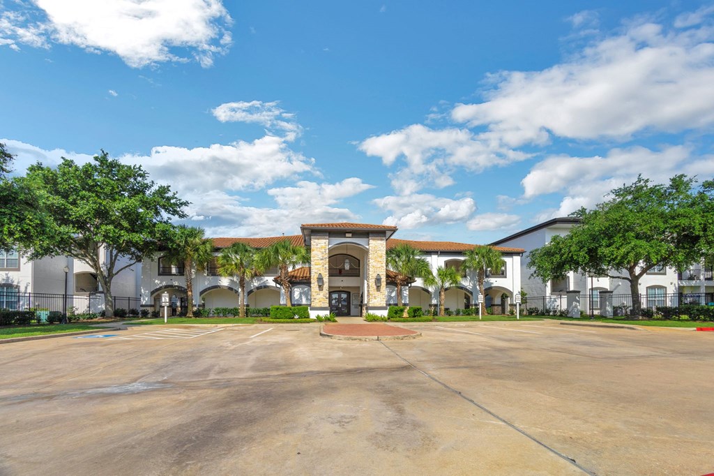a large parking lot in front of a building with trees