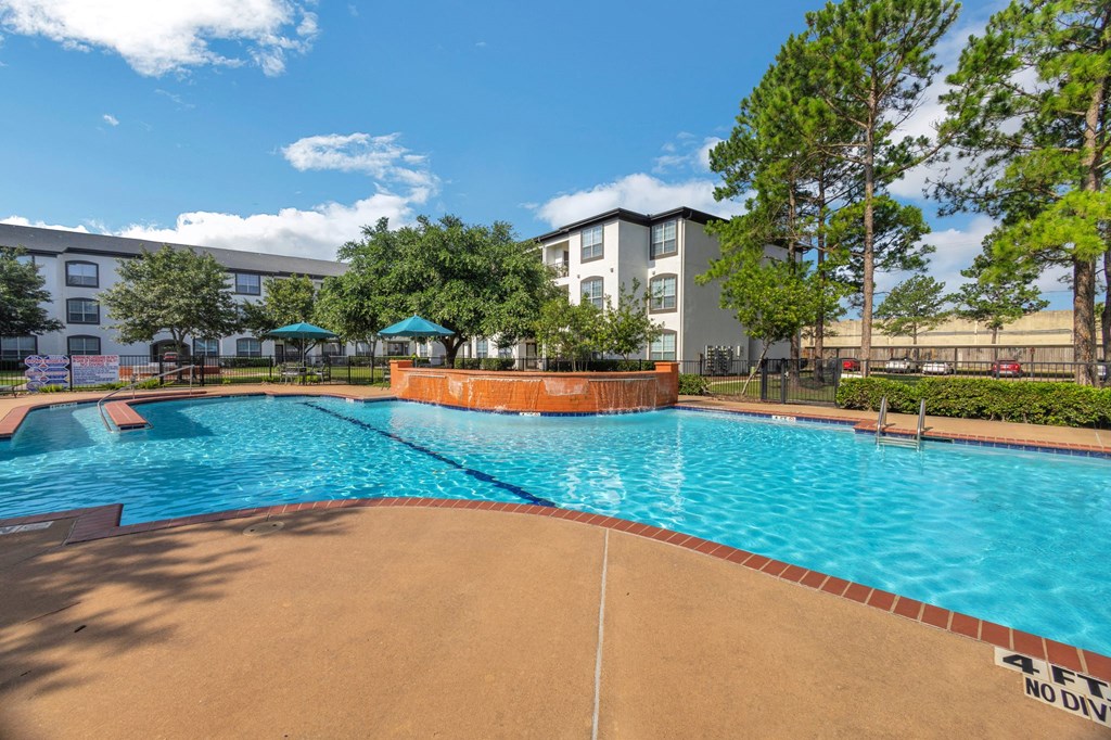 a swimming pool with an apartment building in the background