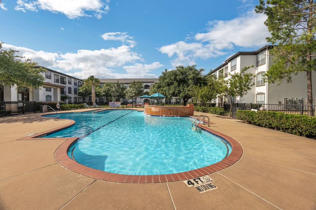 a swimming pool with an apartment building in the background